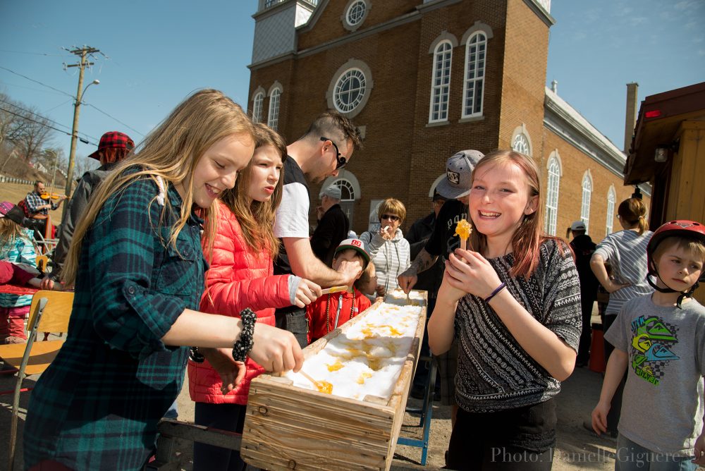 Participants mangent de la tire d'érable à la fête de Pâques à Donnacona